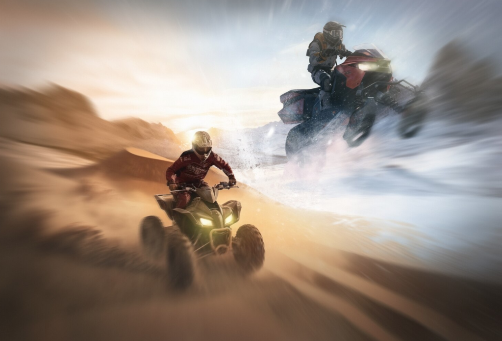 Riders on ATVs race through a desert landscape, creating trails of dust and sand under a dramatic sky.