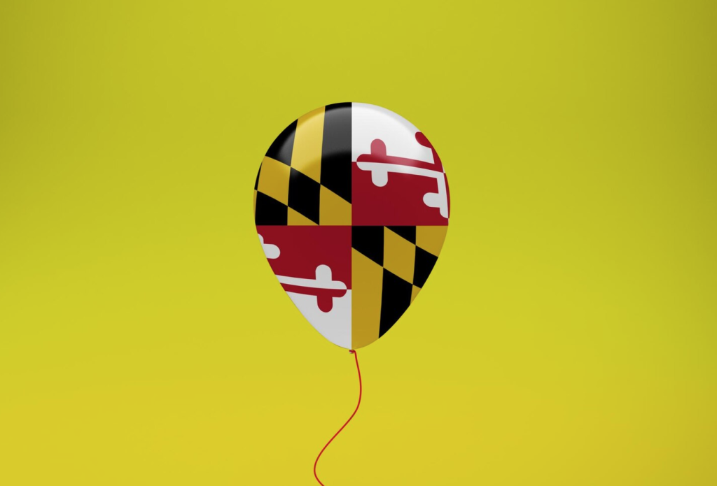 Balloon with Maryland flag design on a yellow background, red string attached.